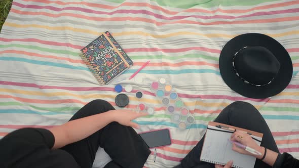 Friends Sitting on Ground Talk and Take Notes in Notebook alt