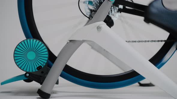 Rotating Rear Wheel of a Stationary Exercise Bike on a White Background