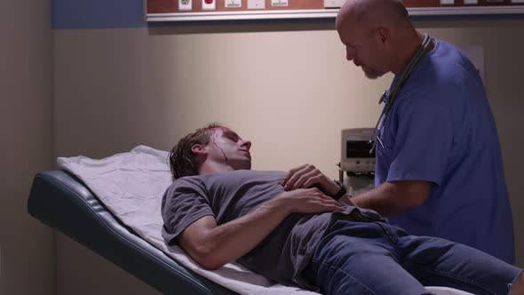 Emergency room doctor examines man with head injury