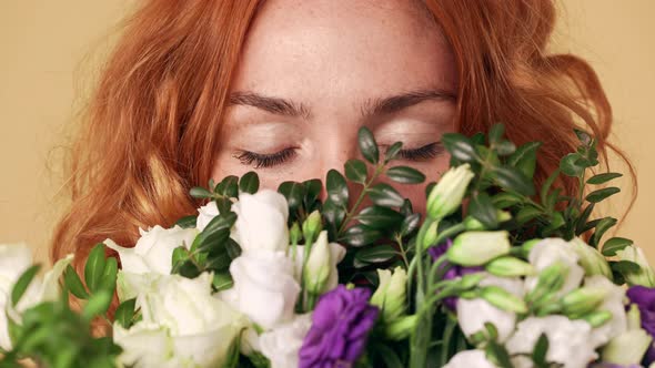 Portrait of Redhead Feminine Woman Holding Colorful Bouquet and Enjoying Smell of Lisianthus Flowers alt