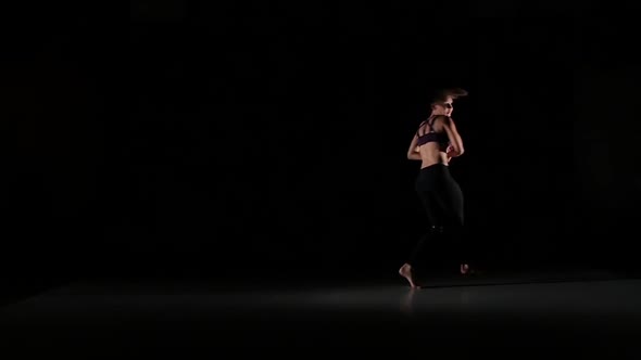 Beautiful Girl Dancing Contemp in the Shadow on Black Background, Slow Motion alt