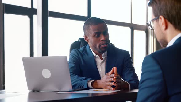 Young african american man hiring new colleague shaking hands after successful job interview alt