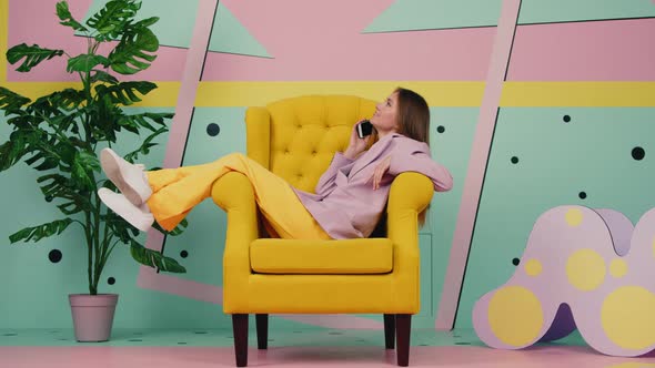 Woman In Yellow Armchair Is Talking Phone