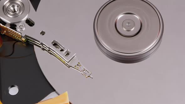 Opened Hard Disk Drive with Spinning Platter. Move of Writing Magnetic Head alt