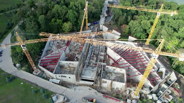 Aerial View Construction of a New Building with High Tower Cranes in Green Area alt