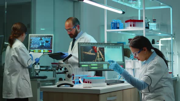 Scientist Team Checking Virus Development Using High Tech alt