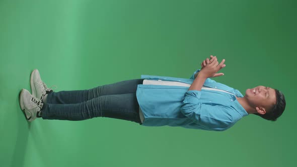 Full Body Of Young Asian Man Clapping Her Hands In The Green Screen Studio. Side View alt