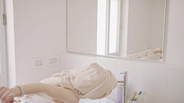 Teenage girl brushing her teeth in the bathroom in the morning alt