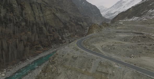 Aerial view of mountain road and two motorcyclists are driving on an empty road. Tranquil Lake Surro alt