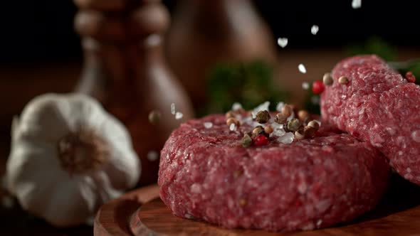 Super Slowmotion Footage of Strewing Salt and Pepper at Fresh Raw Beef Meat Burger 1000Fps alt