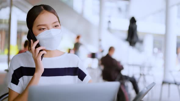 asian female wear casual cloth and face mask protecting hand use smartphone and laptop