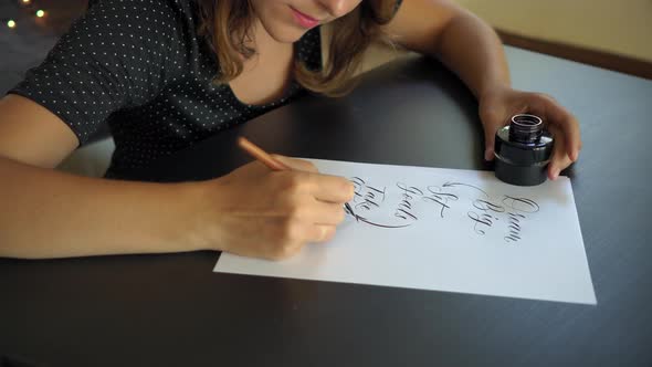 Close Up Shot of a Young Woman Calligraphy Writing on a Paper Using Lettering Technique alt