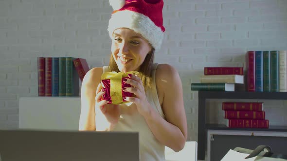 Young Woman in the Office on Christmas Eve in Santa Hat alt