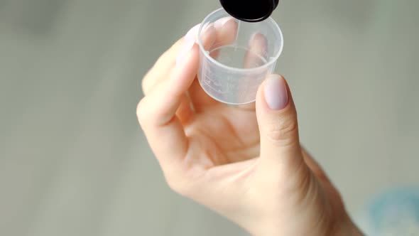 Pharmacy Healthcare Sick Treatment. Pours Cough Syrup Into Spoon. Medicine Antipyretic Syrup Dosage. alt