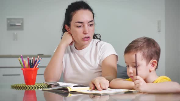 Happy Family Mother Nanny Learning Cute Baby Boy Playing Board Games at Home, Mom Helps Baby Son alt