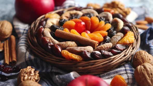 Composition of Dried Fruits and Nuts in Small Wicker Bowl Placed on Stone Table alt