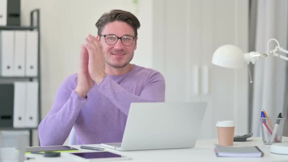 Middle Aged Man with Laptop Clapping alt