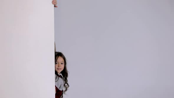 Children Looking Out From Behind White Blank Placard
