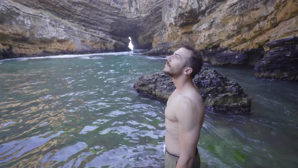 Young man walking on sea cliffs. alt