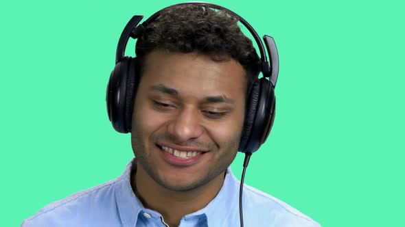 Cheerful Dark-skinned Man Listening Music in Headphones. alt