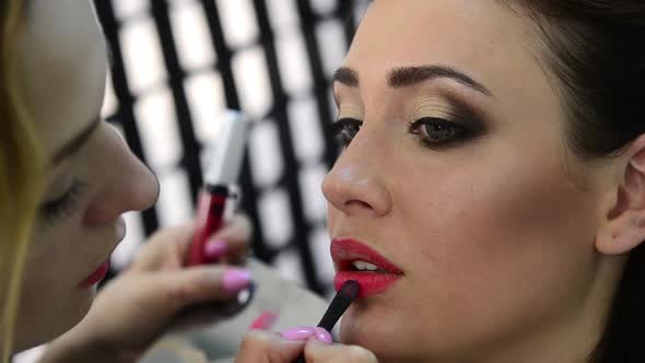 Makeup Artist Applying Lipstick to the Model