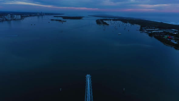 Boat racing to beat the dawn, stunning sunrise, Gold Coast Seaway, Australia alt