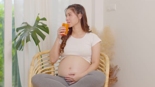 Healthy Pregnant Asian woman Drinking Carrot juice for vitamin A and high in vitamins C alt