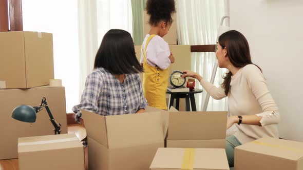 Happy asian women LGBT lesbian couple holding boxes entering new modern house alt