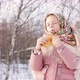 Cute girl in a traditional Russian headscarf with bagels eats pancake on winter background. - VideoHive Item for Sale