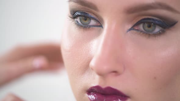 Close-up of the Face of a Girl with Bright Makeup and Purple Lips.