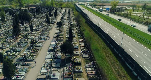 Aerial view of a cemetery neighboring to multiple lane highway. alt