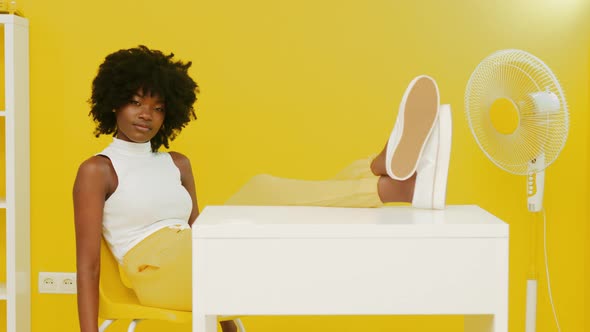 Portrait of African Woman Sitting In Yellow Interior alt