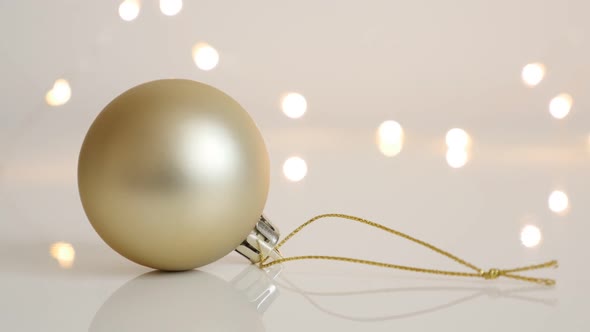 Tilting on bauble in matte golden color 4K 2160p 30fps UltraHD footage - Christmas ornament and shin alt