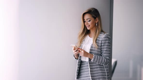 Businesswoman Sending Message with Smartphone in Office alt