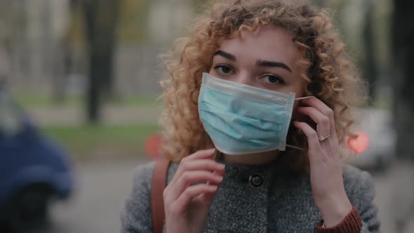 Happy Woman Puts on Protective Mask and Smiling