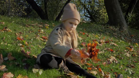 Little Blonde Girl in Autumn Park