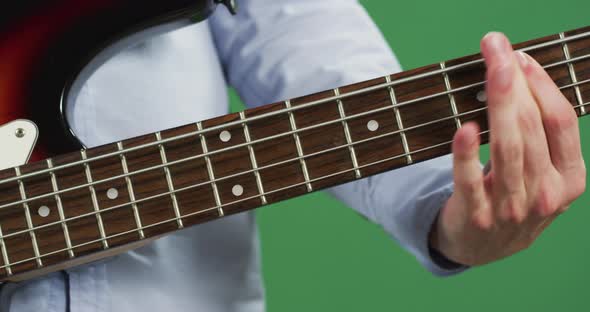 Fingers playing on the fretbaord of an electric guitar alt
