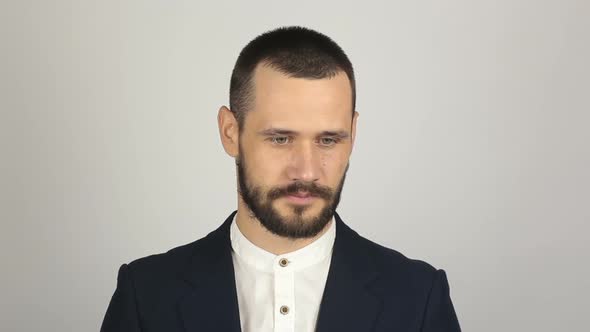 A Young Handsome Businessman in a Blue Suit Is Looking at the Camera and Laughing