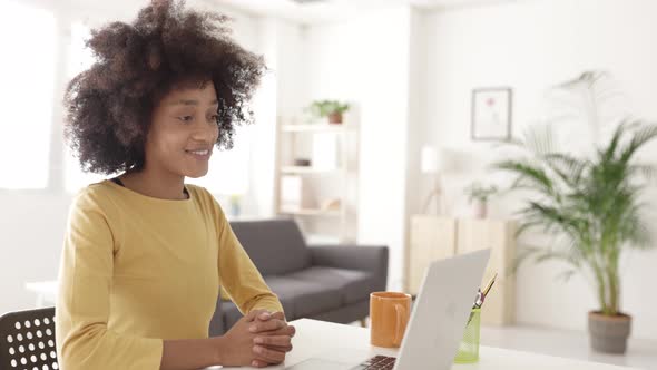 Young African Woman Talking on Video Call Meeting Through Laptop at Home alt