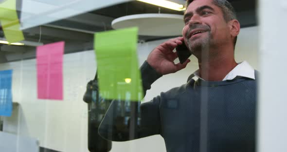 Businessman talking on mobile phone in modern office 