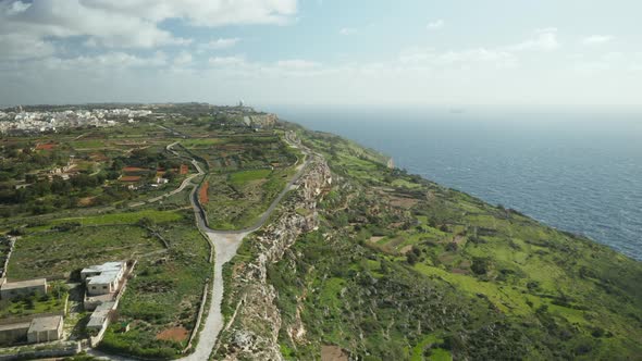 AERIAL: Farmland and Road On Dingli Cliffs with Blue Mediterranean Sea and Clear Sky in Winter
