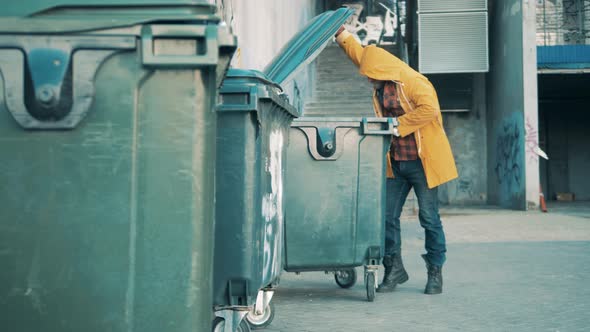 A Tramp is Rummaging in the Trash Bins alt