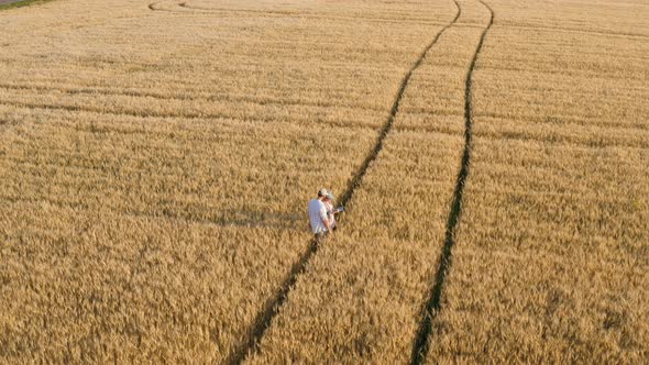 Aerial View Farmers Working with a Tablet in a Wheat Field alt