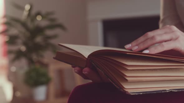 Woman Reads Book at Home. Hand Turning Pages of a Book