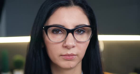 Woman in Glasses Looking at Camera on the Home Background alt