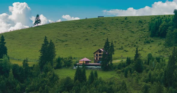 Time lapse. Vacation home in rural area on the hill, clouds passing over the mountain range alt