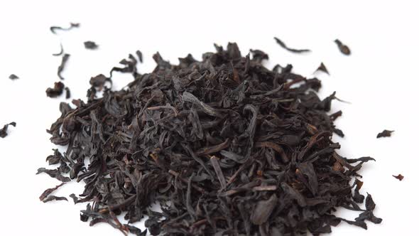 Spoon Sprinkles Black Loose Leaf Tea on a Plate and Spinning Close Up Background for a Cafe or alt