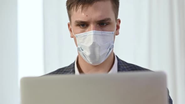 man has put protective mask on face and is working with drawings and plans alt