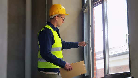 Male Builder with Clipboard Checking Window