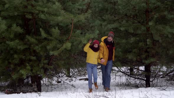 Young Woman and Man Walking in the Forest in Winter alt
